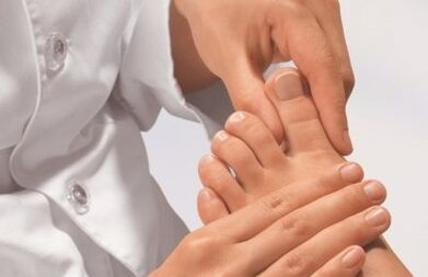 O exame dos dedos do médico com o fungo das pernas